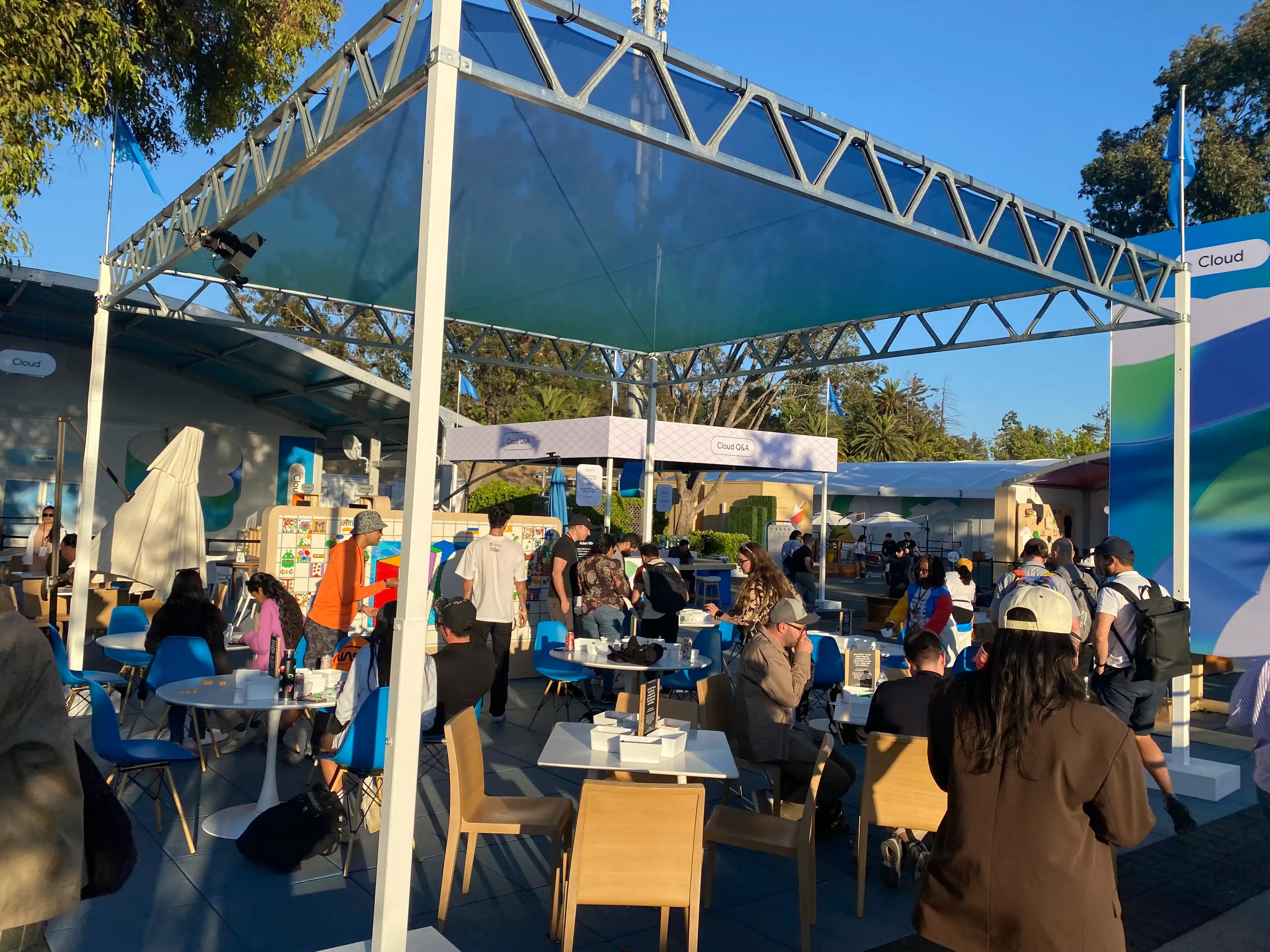 A photo of a special booth-like area with many tables and chairs, filled with numerous people.