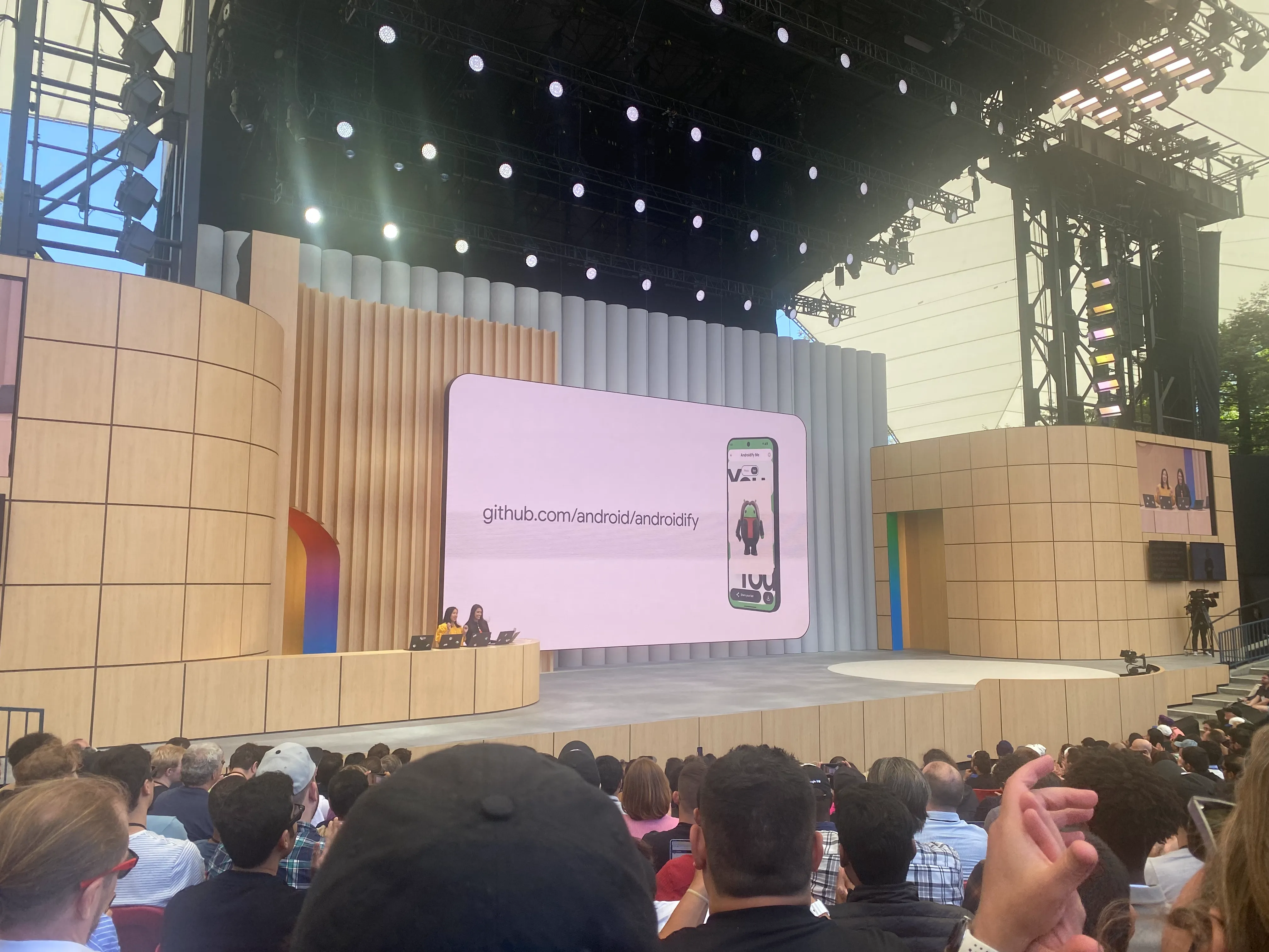 A photo of a session in progress, showing a large screen and a presenter.